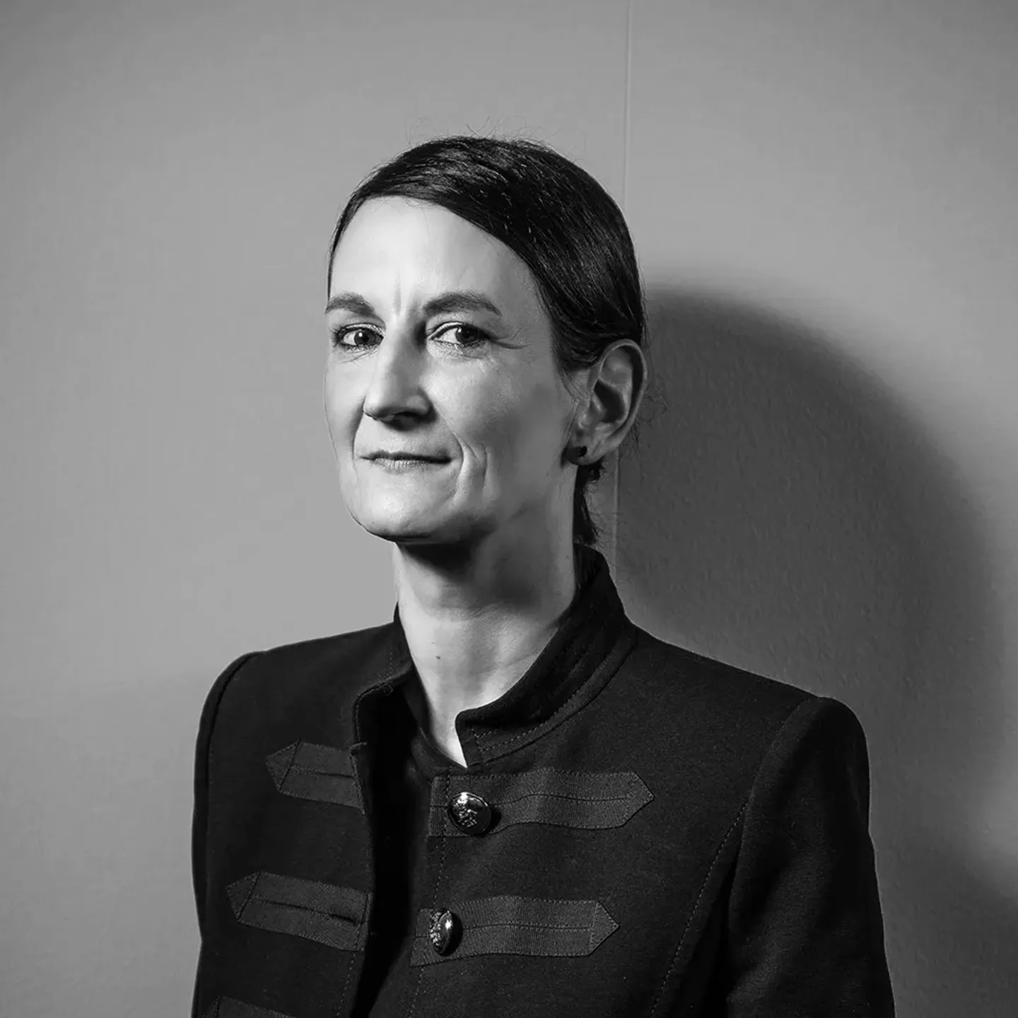Nathalie Kupferschmid schaut verschmitzt in die Kamera, monochrome Farbwelt.